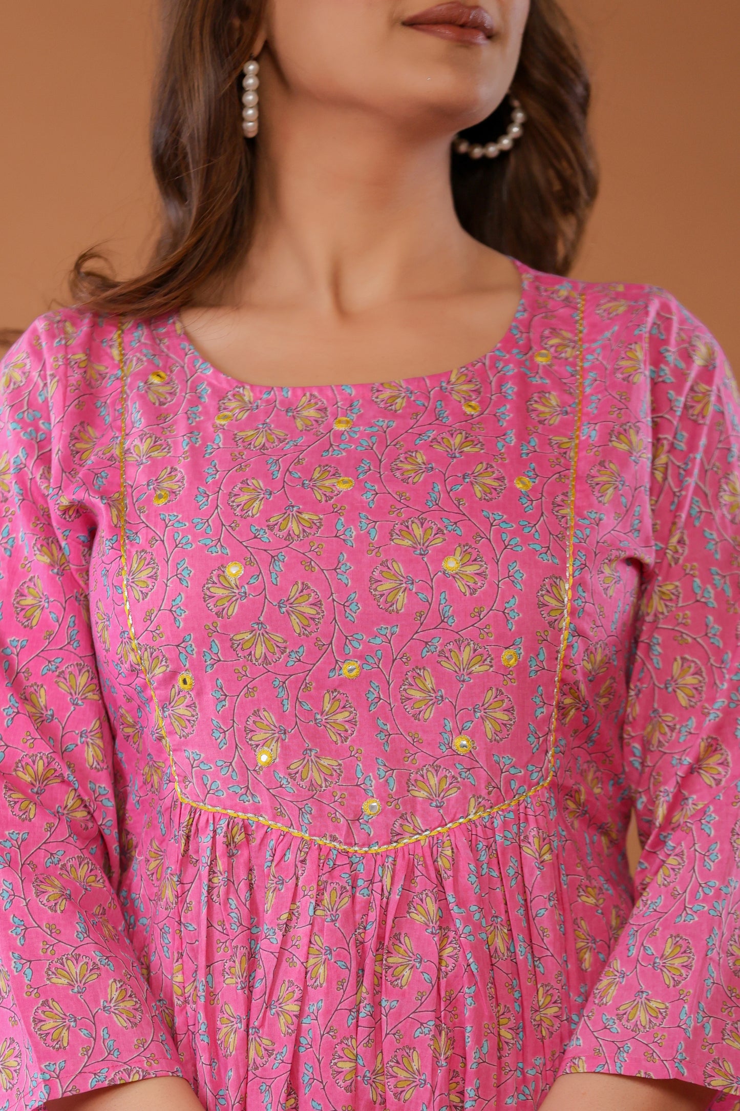 Detailed view of block printed floral pattern on pink cotton fabric